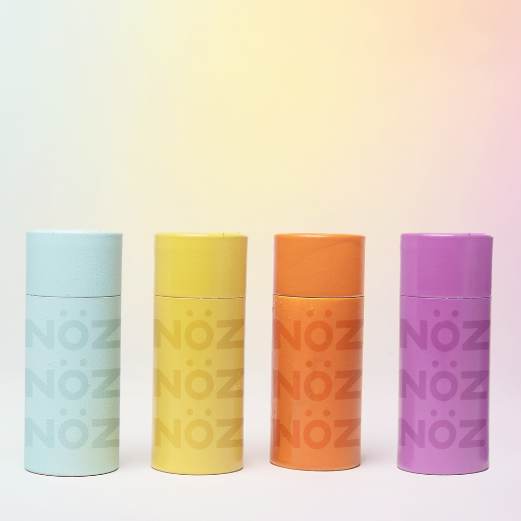 Light blue, yellow, orange, purple sunscreen sticks lined together 